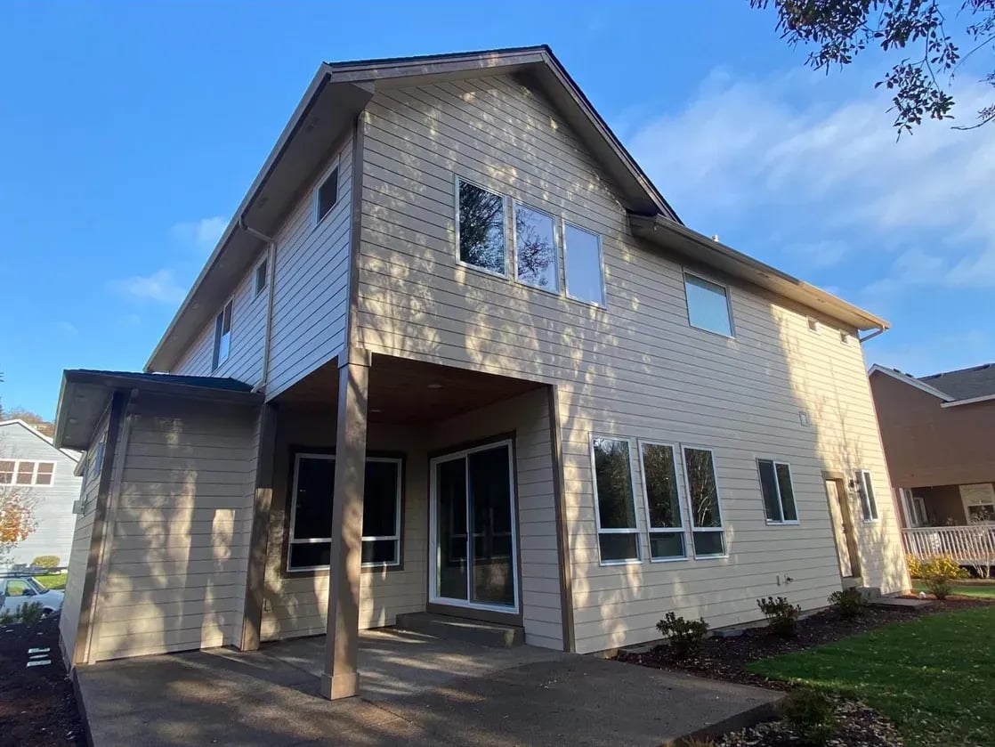 Two-story home with freshly painted beige lap siding and white trim